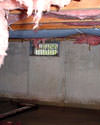 Newfoundland and Labrador crawl space with vents, showing mold, rot, and fiberglass insulation dripping off the ceiling.